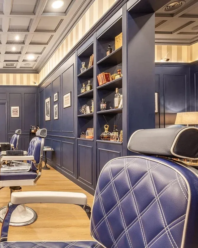 Una poltrona da barbiere in pelle blu trapuntata, da vicino