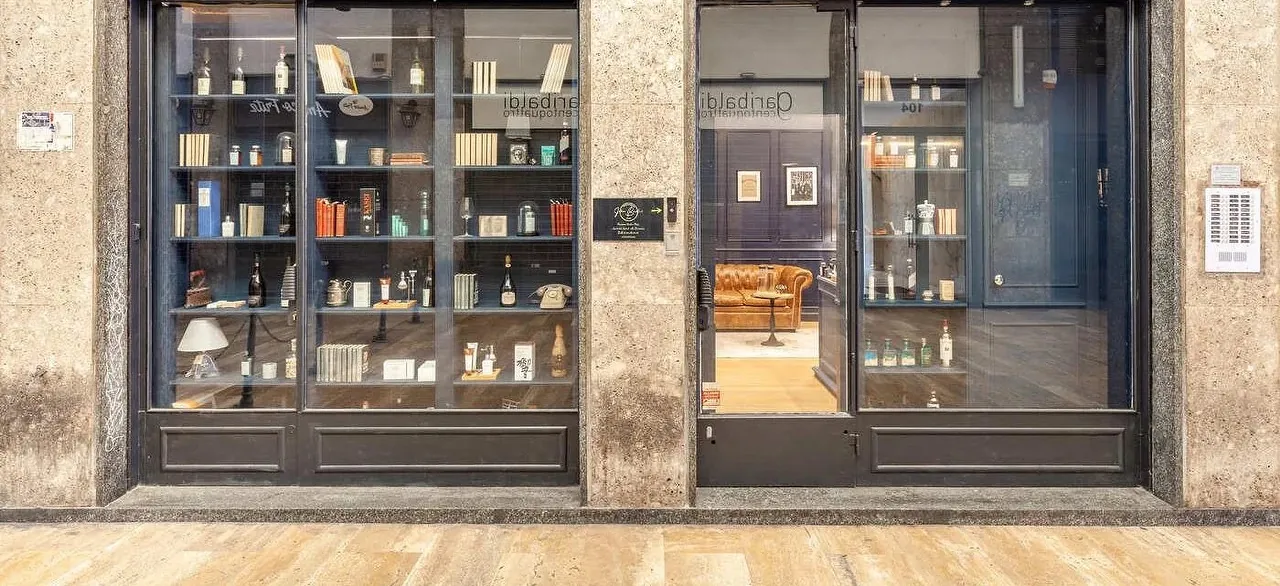 La vetrina di un barbiere, con gli scaffali di prodotti e l'ingresso aperto